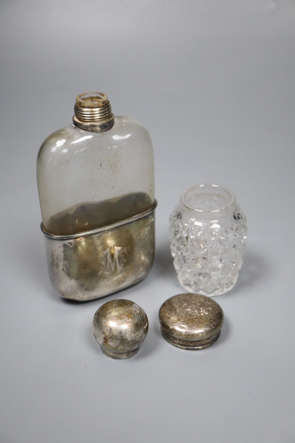 A late Victorian silver mounted glass hip flask, Sheffield, 1890, 14.3cm, an Edwardian silver belt buckle and mounted toilet glass.